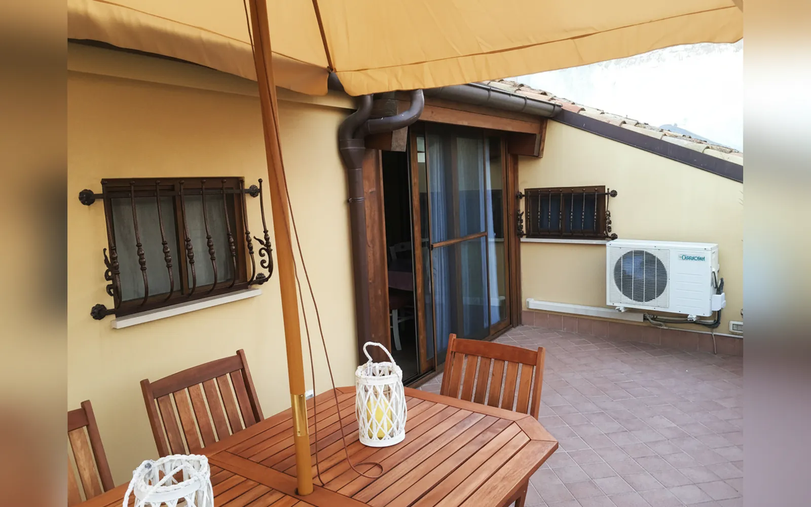 La terrazza privata con il tavolo in legno, l’ombrellone e le lanterne